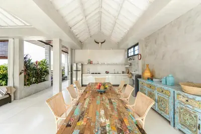 a kitchen with a long wooden table and chairs at DUUR Apartments in Seminyak