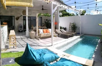 a swimming pool with a patio and a house at Villa Music in Seminyak