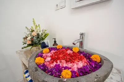 a sink filled with colorful flowers in a bathroom at Villa Music in Seminyak