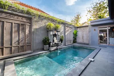 a swimming pool in the backyard of a house at Villa Indah in Legian