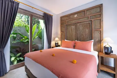a bedroom with a large bed and a large window at Villa Indah in Legian