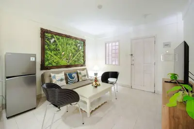 a living room with a table and chairs and a refrigerator at Private Apartment 6244 at Jayakarta Residence in Seminyak