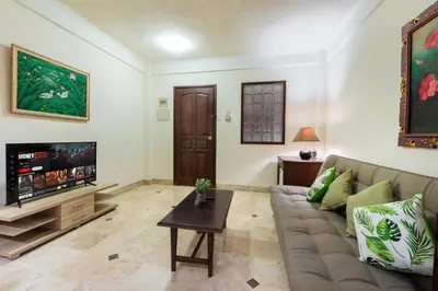 a living room with a couch and a tv at Private Apartment 6503 at the Jayakarta Residence in Seminyak