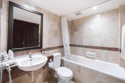 a bathroom with a sink and a toilet and a tub at Private Apartment 6503 at the Jayakarta Residence in Seminyak