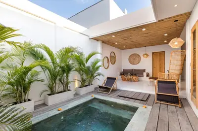 a house with a swimming pool and palm trees at Spacious 1Br Villas in Seminyak in Seminyak