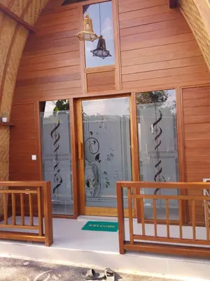 a house with glass doors and a balcony at Thula Thula Bali Villas in Kerobokan