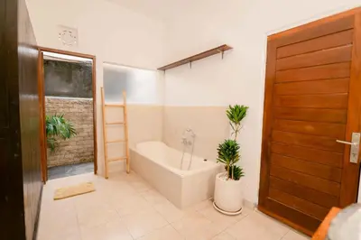 a bathroom with a bath tub and two plants at Amazing 2 Bedroom Villa 5 Min To The Beach - Durna Villa in Canggu