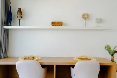 a dining room table with two white chairs at Villa Gregana by Pertama Management in Seminyak