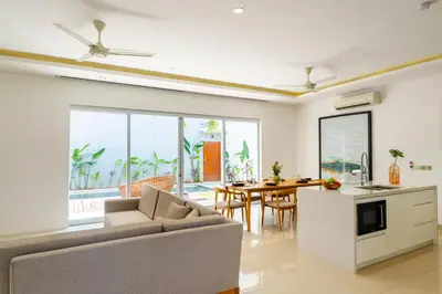 a kitchen and living room with a couch and a table at Villa Gregana by Pertama Management in Seminyak