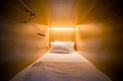 a bedroom with a bed with a light on it at M Boutique Hostel in Seminyak