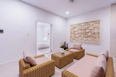 a living room with wicker chairs and a couch at Villa Kamboja 1 Seminyak in Seminyak