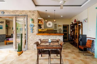 a dining room with a table and a kitchen at Villa Naga, pool, Kitchen, terace and garden in Kerobokan