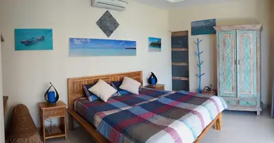 a bedroom with a bed with a colorful blanket at Villa Naga, pool, Kitchen, terace and garden in Kerobokan