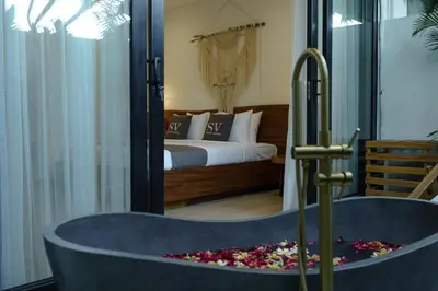 a bath tub in a bedroom with a bed at Sunny Aparts 2 in Canggu