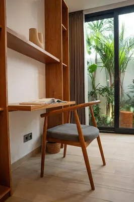 a desk and a chair in a room with a window at Sunny Aparts 2 in Canggu