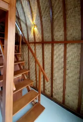 a wooden staircase in a room with a brick wall at Thula Thula Bali Villas in Kerobokan