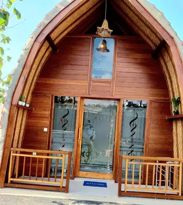 a front door of a wooden building with windows at Thula Thula Bali Villas in Kerobokan