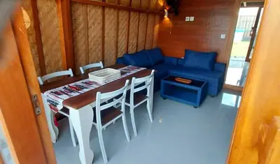 a room with a table and chairs and a blue couch at Thula Thula Bali Villas in Kerobokan