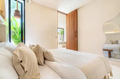 a bedroom with a large white bed with pillows at Casa Admire Villas in Legian