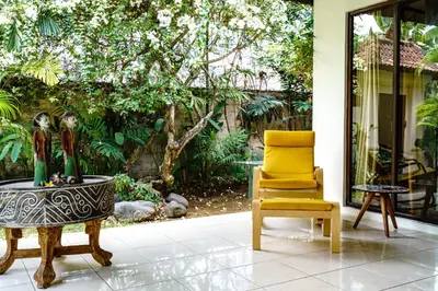 a living room with a chair and a table at Villa Amaro Seminyak in Seminyak