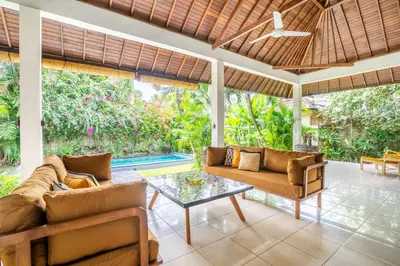 an outdoor living room with couches and a table at Villa Amaro Seminyak in Seminyak