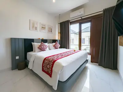 a bedroom with a large bed and a large window at De Amelia Villa Seminyak by Nagisa Bali in Seminyak