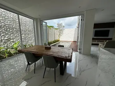 a dining room with a wooden table and chairs at newly built Villa Na Bali in Seminyak