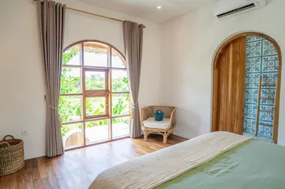 a bedroom with a bed and a large window at Villa Bohemian Seminyak in Seminyak