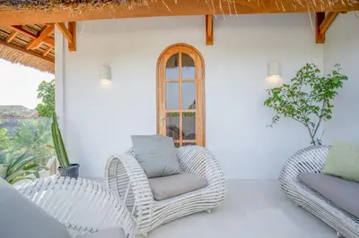 a porch with two chairs and a window at Villa Bohemian Seminyak in Seminyak