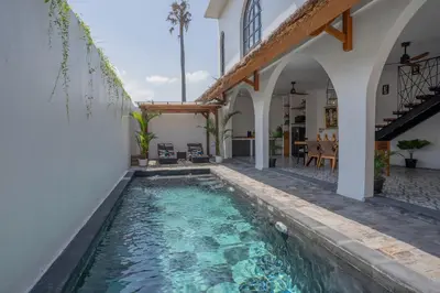 a swimming pool in the middle of a house at Villa Rhapsody Seminyak in Seminyak