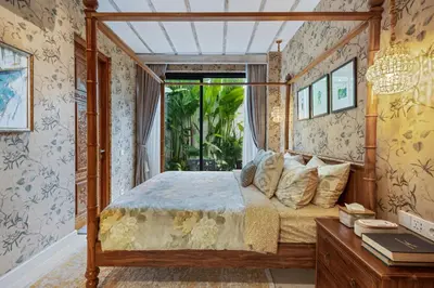 a bedroom with a canopy bed and a window at Luxurious Arakana Villa with Pool in Jimbaran