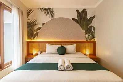 a bedroom with a bed with two slippers on it at Cove Vin Stay in Sanur