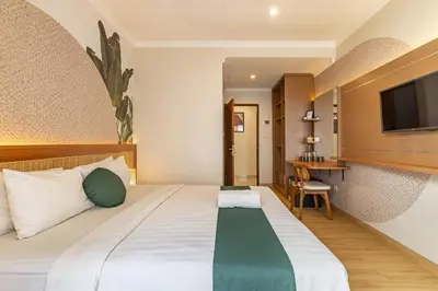 a hotel room with a bed and a television at Cove Vin Stay in Sanur