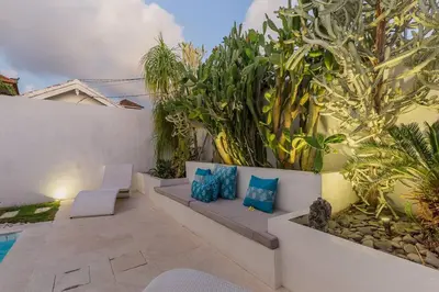 a patio with blue pillows and plants next to a pool at 3 bedr Mediterranean vibes private pool 5min beach in Seminyak