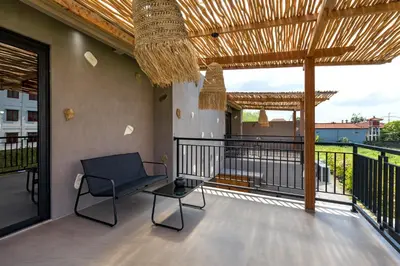 a patio with a chair and a table on a balcony at Atelier 1Br Villas in Seminyak in Seminyak