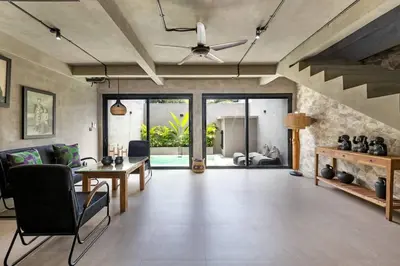 a living room with a ceiling fan and a table at Atelier 1Br Villas in Seminyak in Seminyak