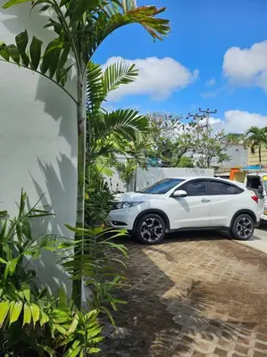 a white car parked next to a palm tree at Nikaya Villa - 3 Bedrooms Near Seminyak in Legian