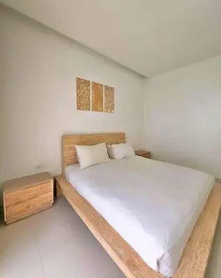 a bedroom with a large bed in a white room at Nikaya Villa - 3 Bedrooms Near Seminyak in Legian