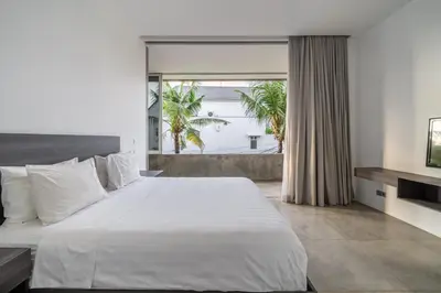 a bedroom with a large white bed and a window at Villa Simpatico Spacious 6 BR Villa Retreat in Central Seminyak in Seminyak