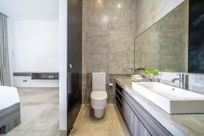 a bathroom with a white toilet and a sink at Villa Simpatico Spacious 6 BR Villa Retreat in Central Seminyak in Seminyak