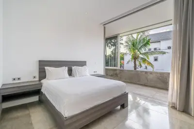 a bedroom with a bed and a large window at Villa Simpatico Spacious 6 BR Villa Retreat in Central Seminyak in Seminyak