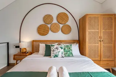 a bedroom with a bed with an arch above it at Cove Anantaha Loft & Villa in Seminyak
