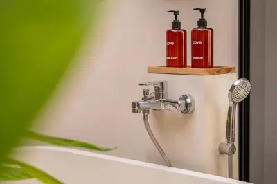 a shower with two red extinguishers on a wall at Cove Anantaha Loft & Villa in Seminyak