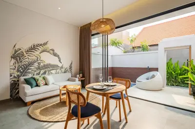 a living room with a couch and a table and chairs at Cove Anantaha Loft & Villa in Seminyak