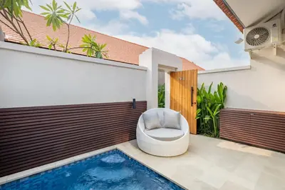 a toilet sitting on a patio next to a swimming pool at Cove Anantaha Loft & Villa in Seminyak