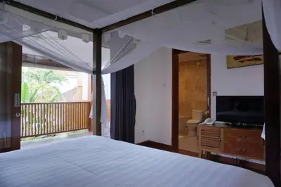 a bedroom with a bed and a television and a balcony at T&J1 - Gorgeous 1BR pool villa, parking, walk to beach! in Umalas
