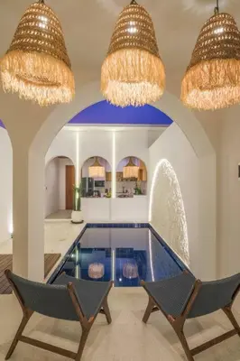 a swimming pool in a house with two chairs and chandeliers at T&J3 - New! Romantic 1BR pool villa in Umalas