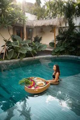 a woman sitting in a swimming pool with a tub in the water at Villa Belle Oasis - Next To Canggu 5BR Tropical Paradise with Private Pool & Stunning Rice Field Views in Kerobokan