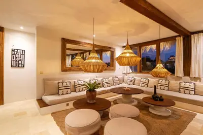 a living room with a couch and tables and windows at Villa Belle Oasis - Next To Canggu 5BR Tropical Paradise with Private Pool & Stunning Rice Field Views in Kerobokan