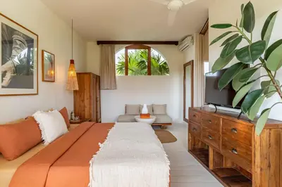 a bedroom with a large bed and a tv at Villa Belle Oasis - Next To Canggu 5BR Tropical Paradise with Private Pool & Stunning Rice Field Views in Kerobokan